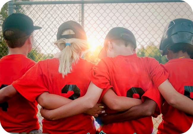 A group of little league baseball players standing arm in arm
